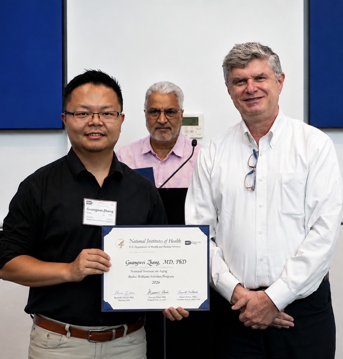 Dr. Guang-Wei Zhang receiving the 2026 NIA Butler-Williams Scholars Program certificate